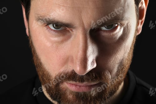 Preview: Evil eye. Man with scary eyes on black background, closeup