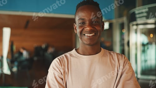 Preview: Close-up of smiling happy young african guy looking at camera