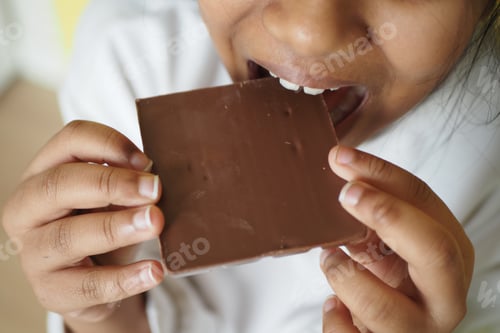 Preview: Girl enjoys chocolate in a casual setting during daytime