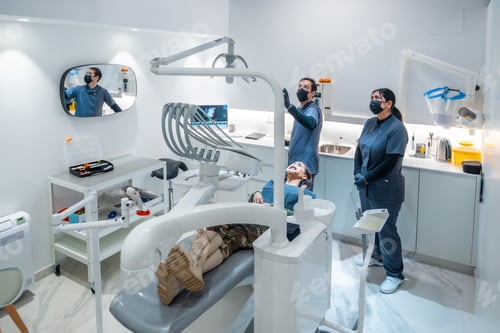 Preview: Dentists showing results of teeth whitening treatment to patient