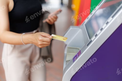 Preview: Businesswoman using credit card at atm for financial transaction