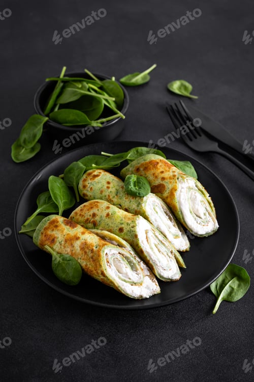 Preview: Savory crepes with spinach and feta cheese on black background