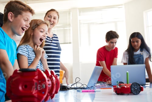Preview: Excited Students Watching Robot Vehicle Move After Coding Lesson In Computer Programing Class
