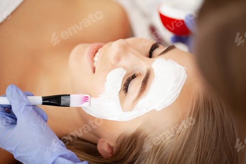 Vista previa: Hermosa mujer con máscara facial en salón de belleza
