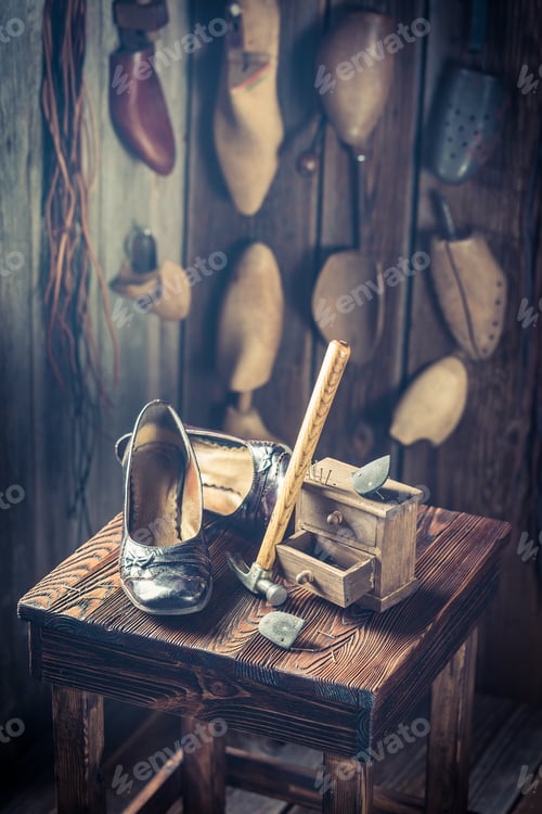 Preview: Aged shoemaker workplace with tools, shoes and leather