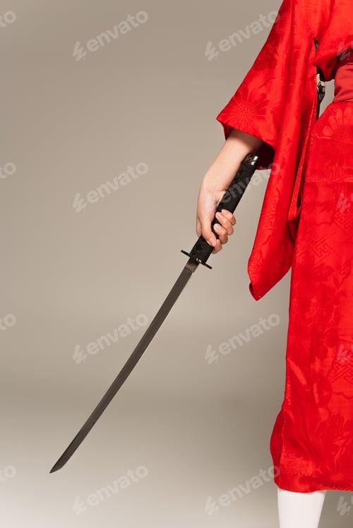Preview: Cropped view of woman in oriental kimono holding sword isolated on grey