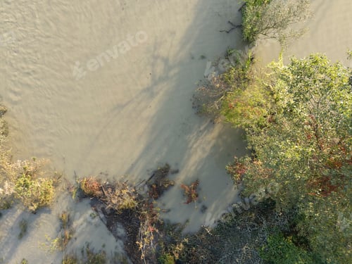 Preview: River flooding over its banks covering surrounding trees and land in Emilia Romagna, Italy