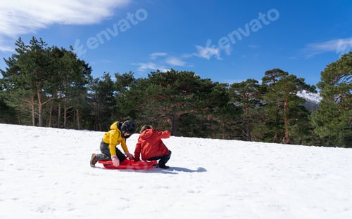 Preview: Kids preparing for sledding together in winter snow