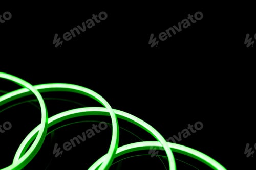 Preview: Image of vibrant spiral green neon glow sticks over black background with copy space