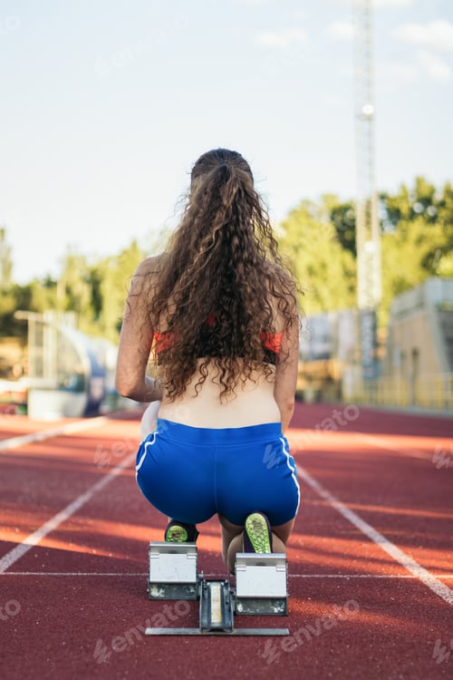 Preview: female athlete prepared to run on an athletics track