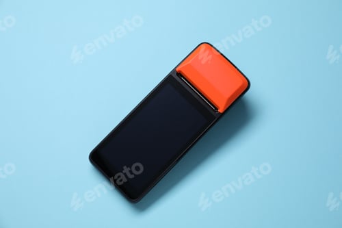 Preview: One payment terminal on light blue background, top view