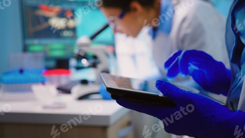 Preview: Close up of scientist writing on tablet