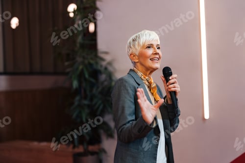 Preview: Concentrated woman giving a speech to the other business clients.