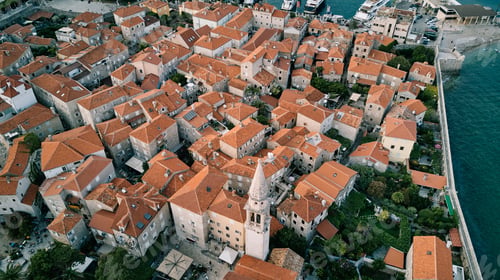 Preview: White bell tower of the Church of St. Ivan among the red roofs of the ancient houses of Budva