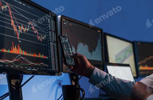Analyzing data. Stock trader working in the office with exchange technology