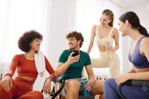 Preview: Engaged individuals sharing moments of joy and camaraderie in a modern pilates studio