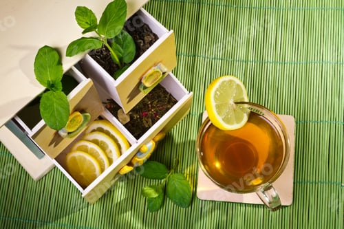 Preview: Hot cup of tea and cupboard on bamboo mat
