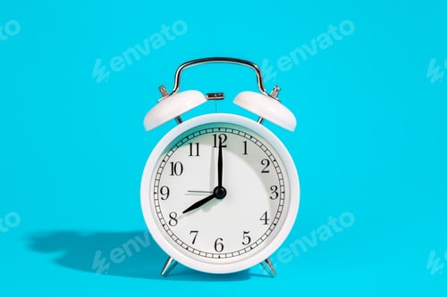 Preview: White alarm clock on a blue background isolated, close-up.