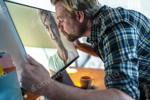 Preview: Man kissing woman on computer screen
