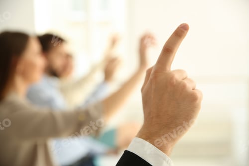 Preview: Man raising hand to ask question at business training indoors, closeup