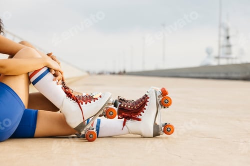 Preview: Feet of two women with roller skates on the street.