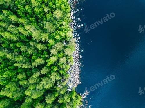 Preview: Aerial view of blue water lake with stone coast and green summer woods in Finland