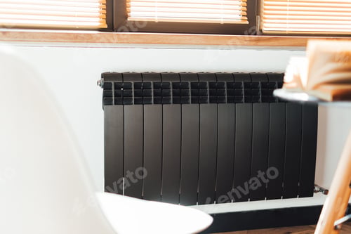 Preview: Black aluminum alloy metal heating radiator for home. Black heating battery on the white wall