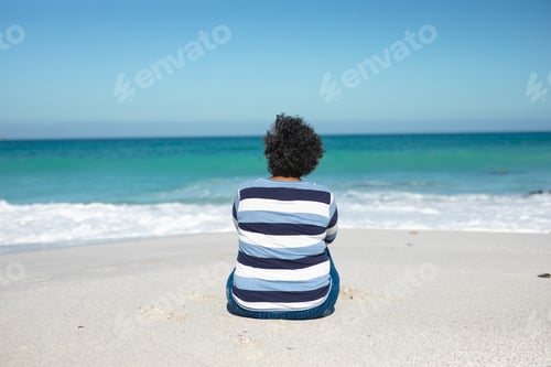 Preview: Old woman sitting on the sand
