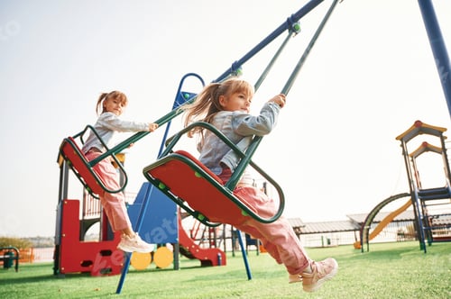 Preview: Enjoying swing ride. Kids are having fun on the playground