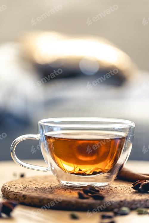 Preview: Close-up, glass cup of aromatic black tea on a blurred background.
