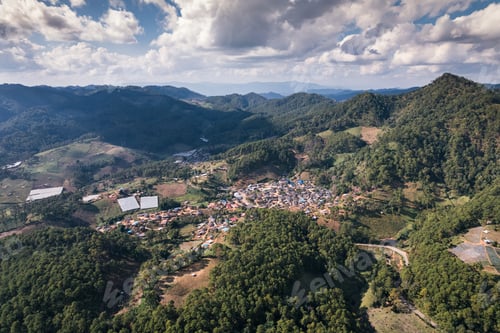 Preview: Aerial view of local village in the valley among tropical rainforest at countryside