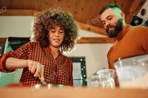 Preview: Couple cooking together in modern kitchen, preparing ingredients