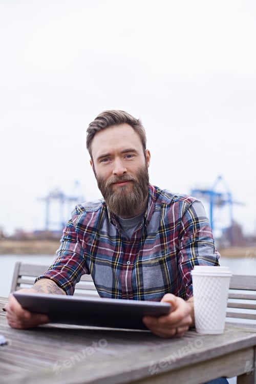 Preview: Portrait of young male designer on waterfront outside design studio