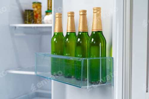 Preview: Four bottles of beer on shelf in fridge