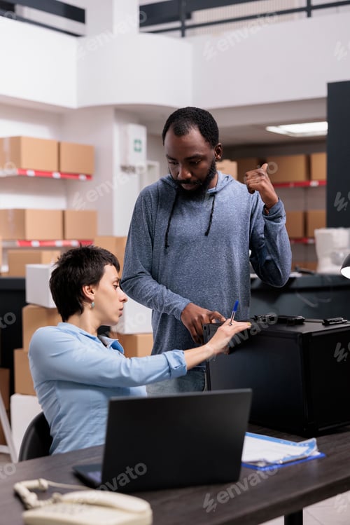 Preview: Storehouse delivery workers checking metallic box looking at package order while working at