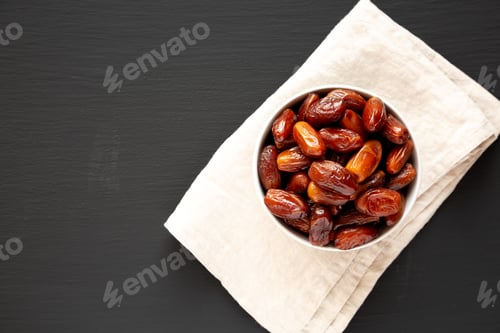 Preview: Organic Dry Deglet Nour Dates in a Bowl, top view. Copy space.
