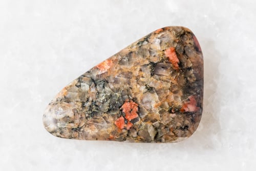 Preview: sample of tumbled gneissoid granite rock on white
