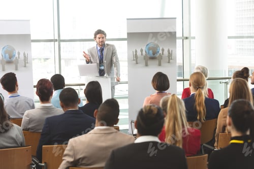 Preview: Businessman with laptop speaks at business seminar in office building