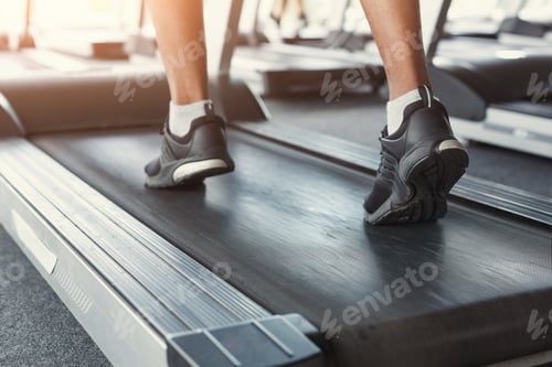 Preview: Man's feet on treadmill in fitness club, healthy lifestyle