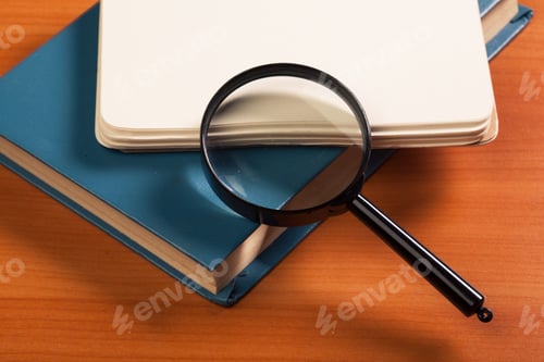 Preview: Notebook and magnifier on a wooden background
