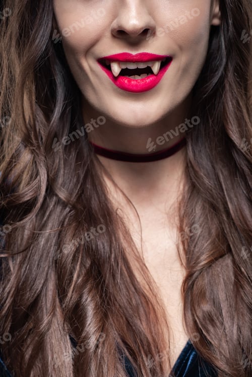 Preview: cropped view of woman showing vampire fangs