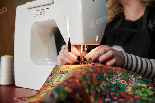 Preview: A woman threading a needle on a sewing machine, sewing upholstery fabric.