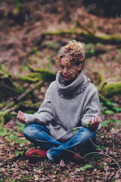 Preview: Woman sit down outdoor in the middle of nature and forest woods meditate in lotus yoga position