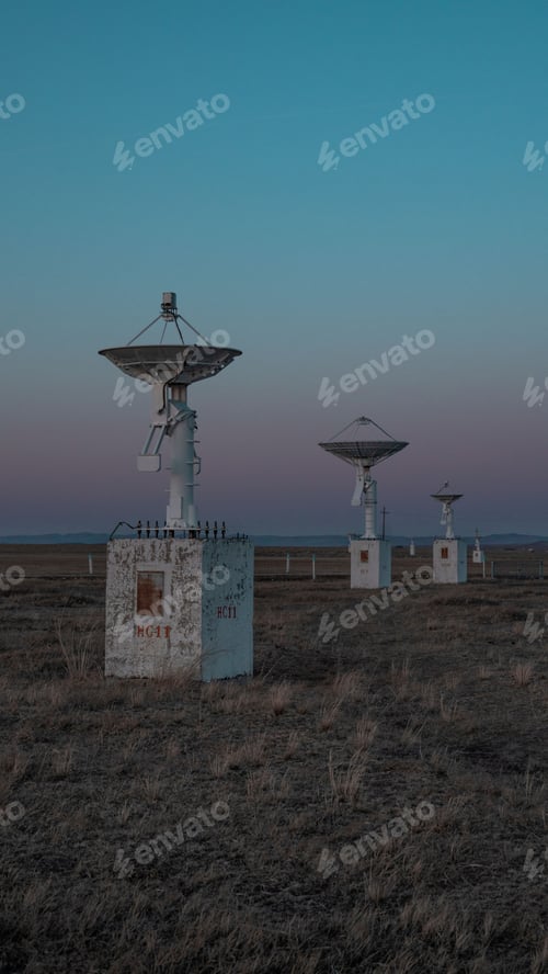 Preview: Vertical shot of a row of radio telescopes in the field