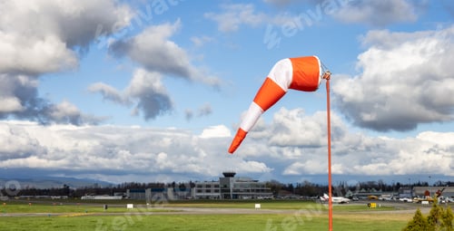 Preview: Windsock at an airport with a cloudy sunny sky in background