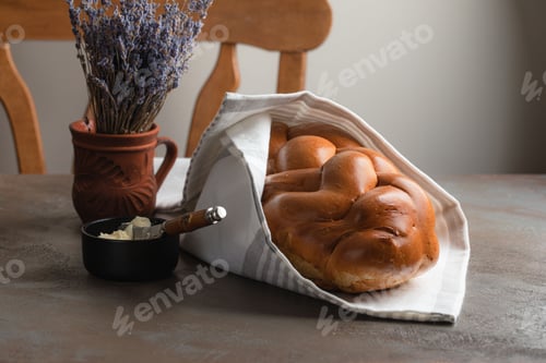 Preview: Closeup shot of a traditional Jewish bread, challah, on a wooden table.