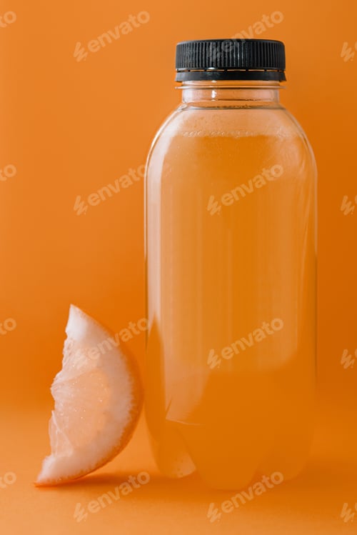 Preview: Bottle of fresh orange juice on yellow background