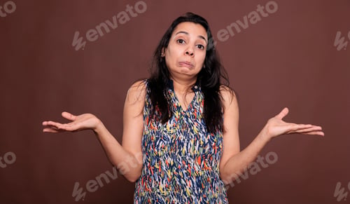 Preview: Confused indian woman shrugging shoulders with doubting facial expression