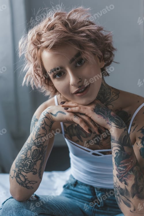 Preview: portrait of beautiful tattooed girl with pink hair in bedroom