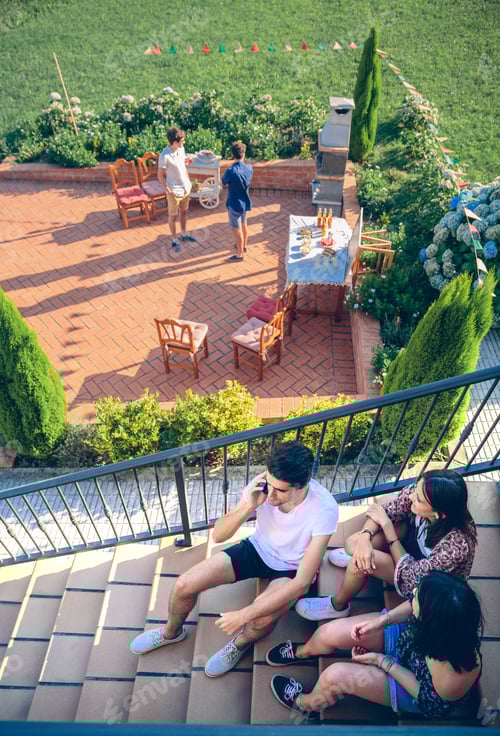 Preview: Young man calling by phone sitting on home stairs